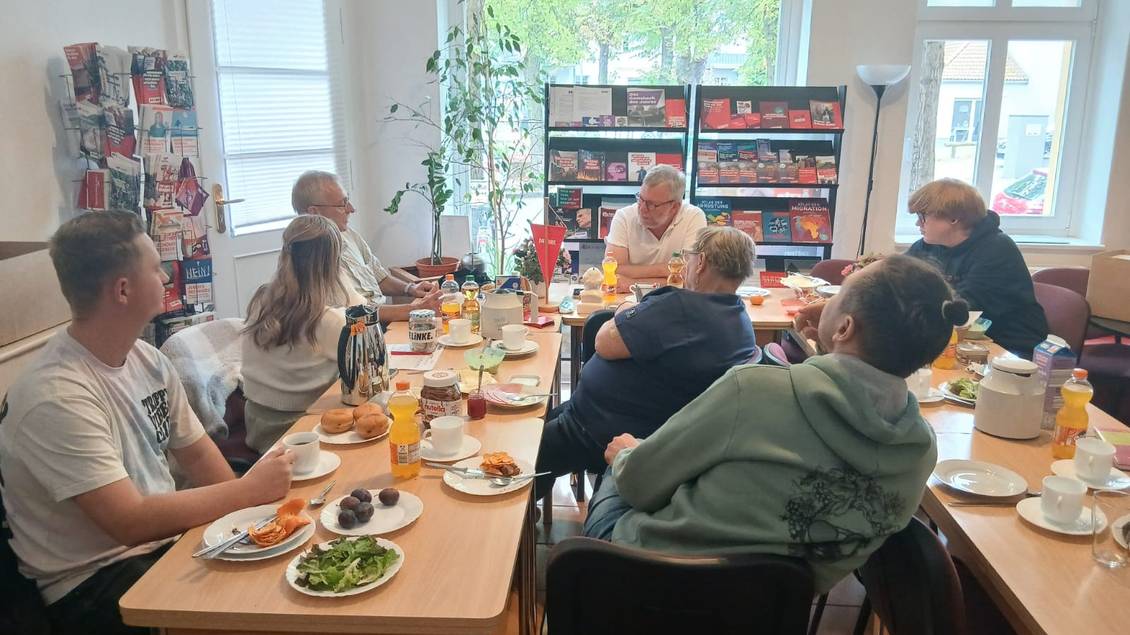 Das Foto zeigt mehrere Personen an Tischen sitzend.