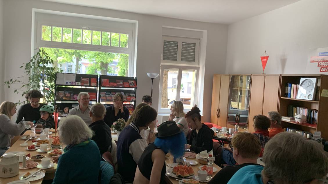 Das Foto zeigt eine Gruppe von Menschen, die im Linkstreff in Luckenwalde zusammen an Tischen sitzt.