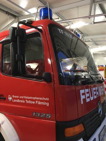 Das Foto zeigt in der Nahaufnahme ein Feuerwehrauto mit der Aufschrift "Brand- und Katastrophenschutz Landkreis Teltow-Fläming"."